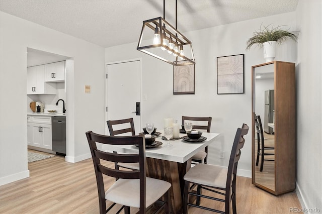7770 W 38th Ave Unit 108, Wheat Ridge, CO 80033 - dining room featuring a textured ceiling, light wood-style flooring, and baseboards
