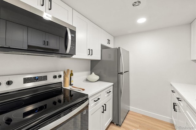 7770 W 38th Ave Unit 108, Wheat Ridge, CO 80033 - kitchen featuring white cabinets, light countertops, light wood-type flooring, and stainless steel appliances