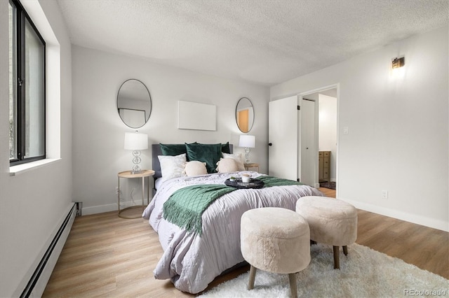 7770 W 38th Ave Unit 108, Wheat Ridge, CO 80033 - bedroom with light wood finished floors, a textured ceiling, baseboards, and baseboard heating