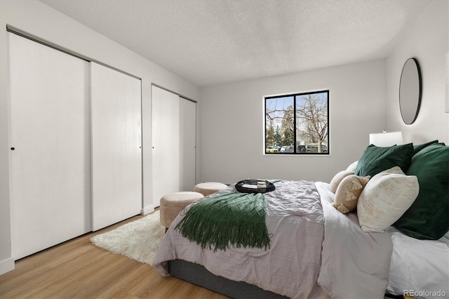 7770 W 38th Ave Unit 108, Wheat Ridge, CO 80033 - bedroom with a textured ceiling, multiple closets, and wood finished floors