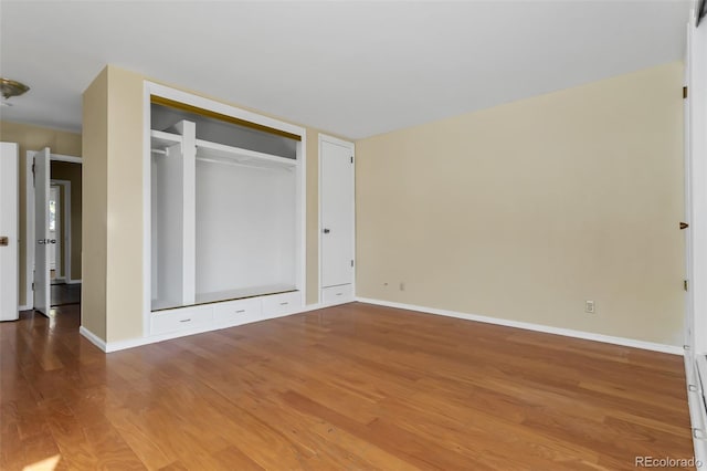 unfurnished bedroom featuring a closet and hardwood / wood-style floors