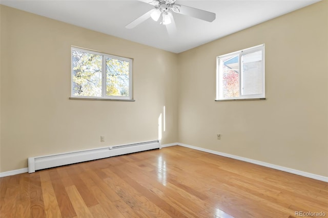 spare room featuring plenty of natural light, light hardwood / wood-style flooring, ceiling fan, and a baseboard heating unit