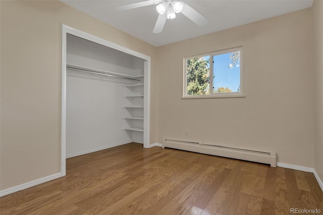 unfurnished bedroom featuring a closet, light hardwood / wood-style floors, ceiling fan, and a baseboard heating unit