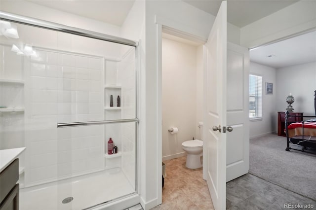 bathroom with vanity, toilet, and a shower with door