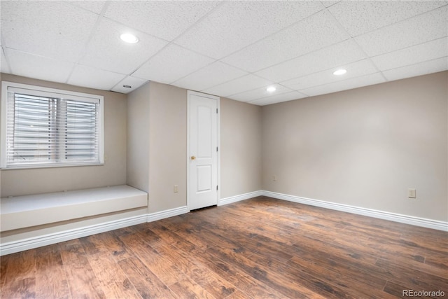 interior space featuring dark hardwood / wood-style flooring and a drop ceiling