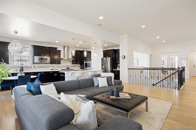 living room featuring a notable chandelier and light hardwood / wood-style floors