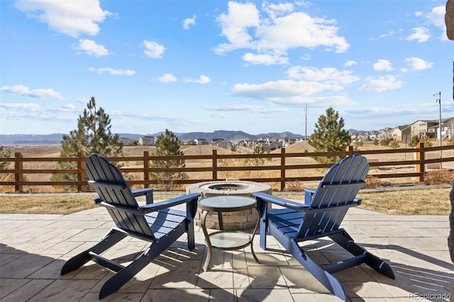 view of patio with a mountain view and an outdoor fire pit