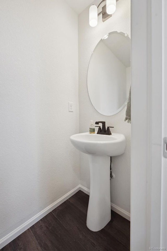 bathroom with wood finished floors and baseboards