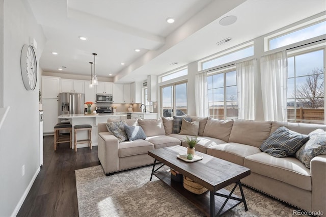 living area featuring baseboards, visible vents, dark wood finished floors, and recessed lighting