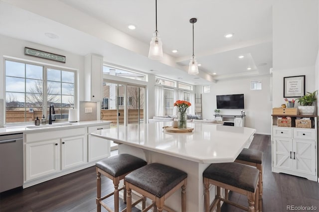 kitchen featuring dark wood-style floors, a sink, white cabinets, light countertops, and dishwasher