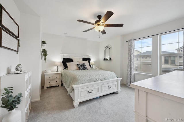 bedroom with light carpet and a ceiling fan