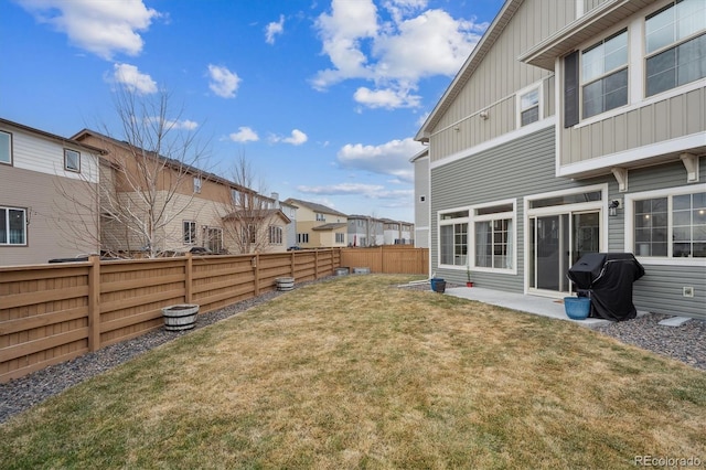 view of yard featuring a residential view, a fenced backyard, and a patio