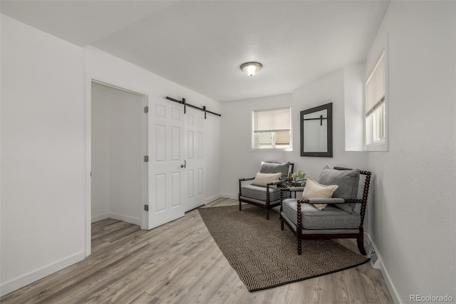 7828 Florado St, Denver, CO 80221 - living area with a barn door, baseboards, and light wood finished floors