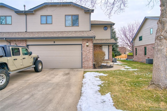 view of front of property with a garage, cooling unit, and a front lawn