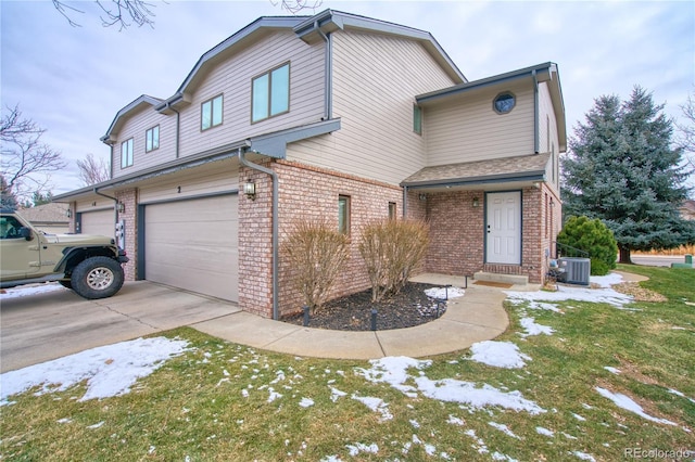 view of front of home featuring a garage, a front lawn, and central AC