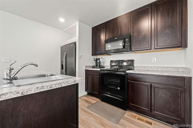 kitchen featuring dark brown cabinets, black appliances, sink, and light wood-type flooring