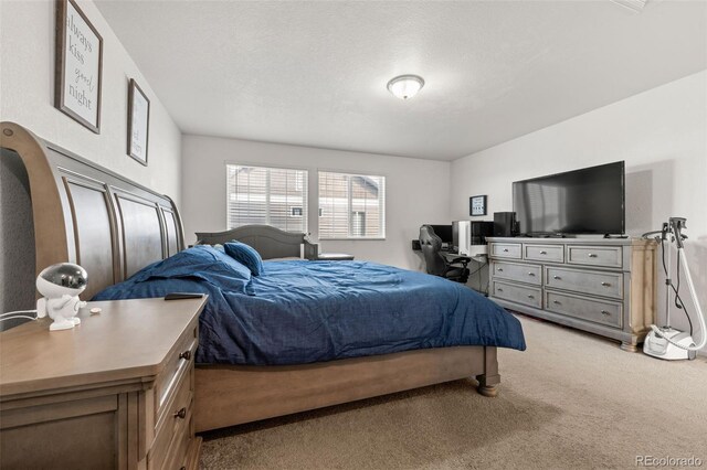 bedroom featuring a textured ceiling and light colored carpet