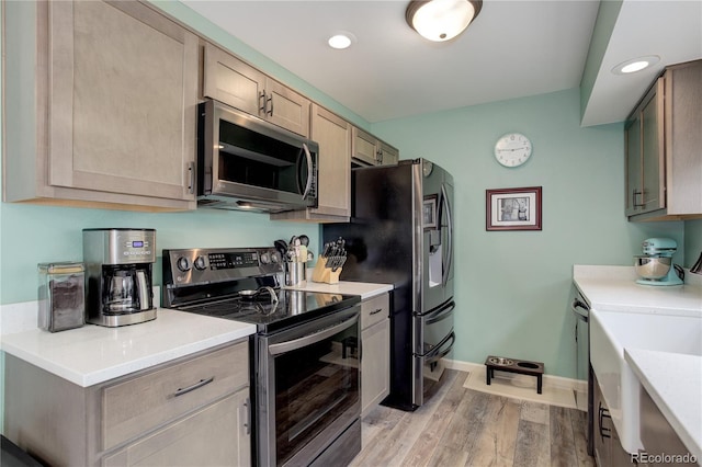 7840 S Windermere Cir, Littleton, CO 80120 - kitchen featuring stainless steel appliances, light wood-style floors, light countertops, baseboards, and light brown cabinets