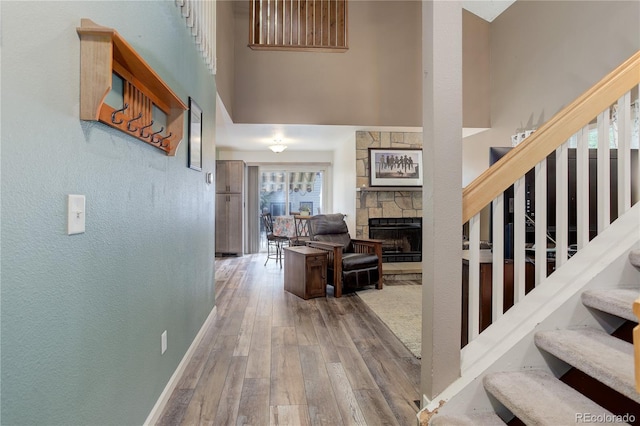 7840 S Windermere Cir, Littleton, CO 80120 - entryway featuring stairway, hardwood / wood-style flooring, a fireplace, a towering ceiling, and baseboards