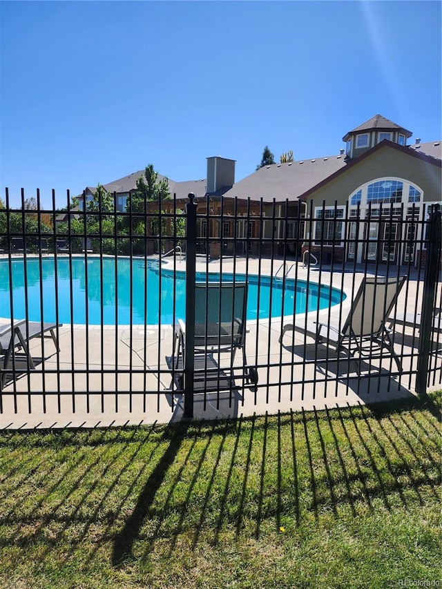 view of pool featuring a yard and a patio