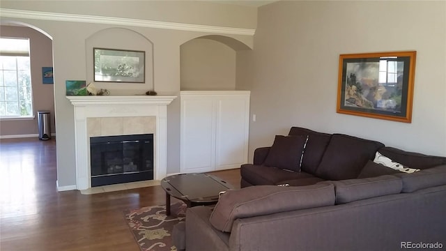 living room featuring a tiled fireplace and dark hardwood / wood-style floors