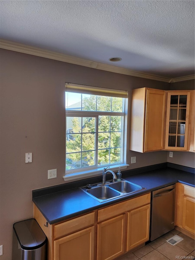 kitchen with sink, a textured ceiling, stainless steel dishwasher, ornamental molding, and light tile patterned floors