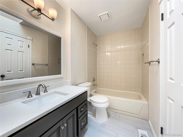 full bathroom with tiled shower / bath, vanity, toilet, and tile patterned flooring