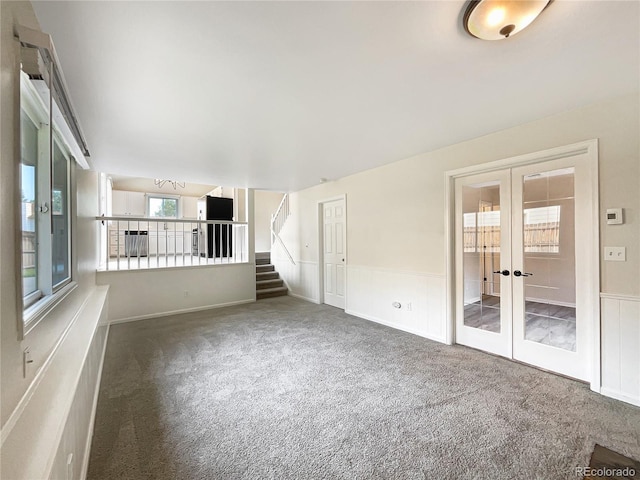 unfurnished living room with french doors and carpet