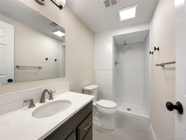 bathroom with tile patterned flooring, vanity, decorative backsplash, toilet, and walk in shower