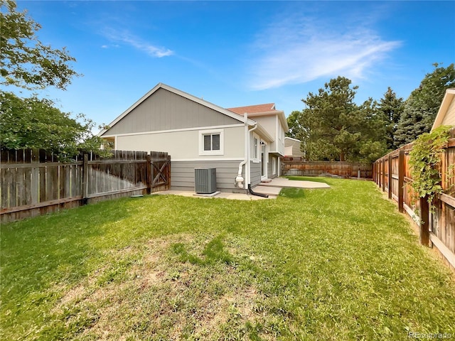 back of property with a yard, cooling unit, and a patio area