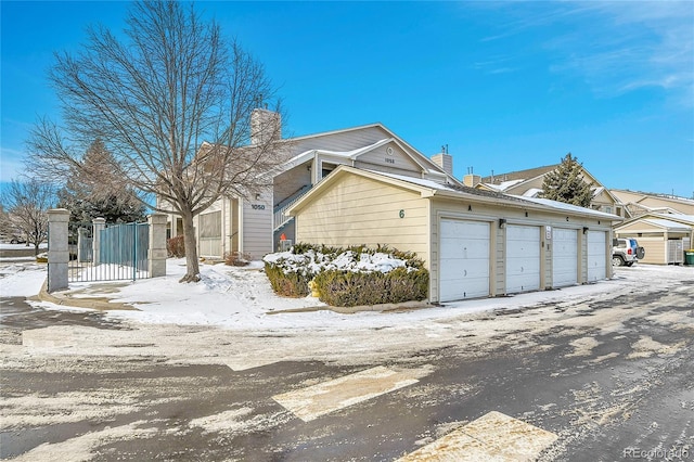 snow covered property featuring a garage