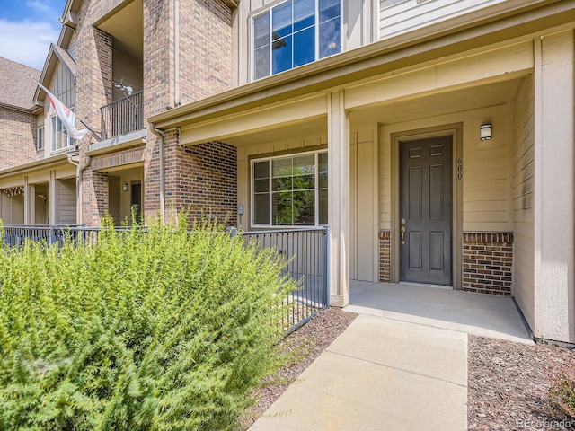 600 E Dry Creek Pl, Littleton, CO 80122 - doorway to property featuring brick siding and covered porch