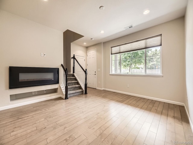 600 E Dry Creek Pl, Littleton, CO 80122 - unfurnished living room featuring stairs, wood finished floors, and recessed lighting