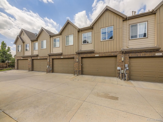 600 E Dry Creek Pl, Littleton, CO 80122 - townhome / multi-family property with board and batten siding, brick siding, driveway, and a garage