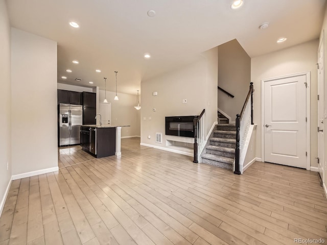 600 E Dry Creek Pl, Littleton, CO 80122 - unfurnished living room with stairs, light wood-type flooring, and recessed lighting