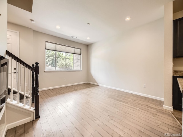 600 E Dry Creek Pl, Littleton, CO 80122 - unfurnished living room with stairs, light wood-style floors, and recessed lighting