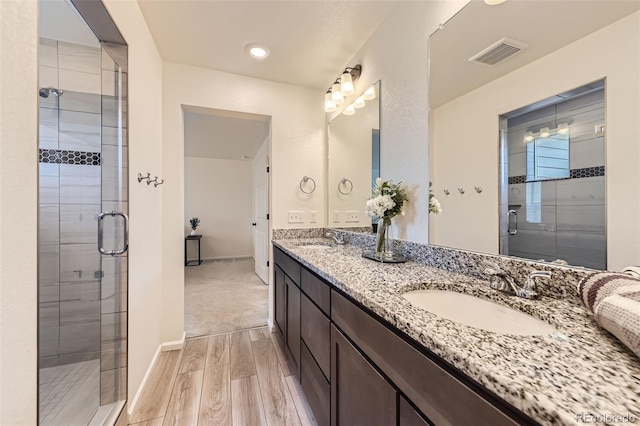 4433 N Picadilly Ct, Aurora, CO 80019 - bathroom featuring wood finished floors, double vanity, a stall shower, and baseboards