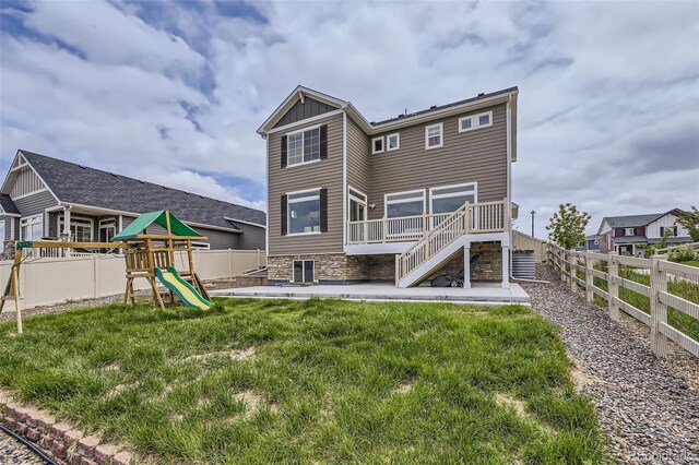 4433 N Picadilly Ct, Aurora, CO 80019 - rear view of house featuring a playground, stairway, a patio, board and batten siding, and a wooden deck