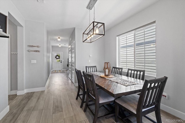 3344 Evening Pl, Castle Rock, CO 80109 - dining area featuring light wood-type flooring, baseboards, and a chandelier