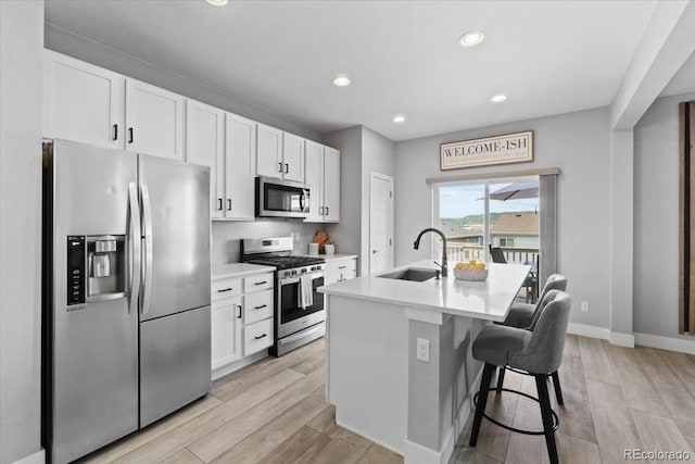 3344 Evening Pl, Castle Rock, CO 80109 - kitchen featuring stainless steel appliances, a sink, white cabinetry, light wood-type flooring, and recessed lighting