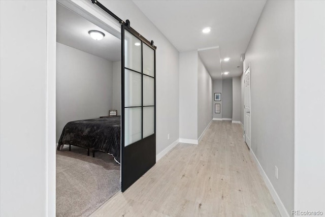 3344 Evening Pl, Castle Rock, CO 80109 - hallway with a barn door, wood finished floors, recessed lighting, and baseboards