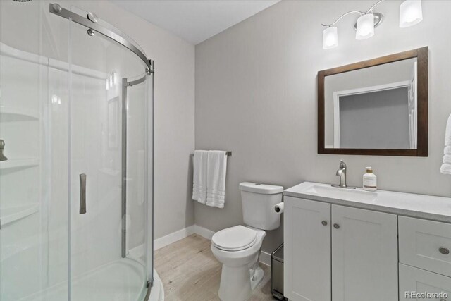 3344 Evening Pl, Castle Rock, CO 80109 - bathroom with vanity, a stall shower, wood finished floors, toilet, and baseboards