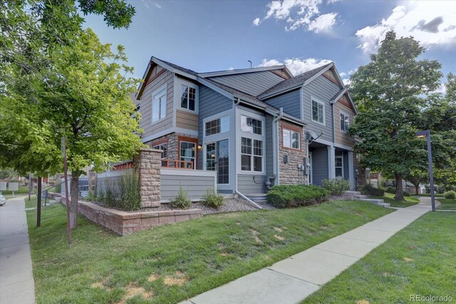 12812 Jasmine St Unit D, Thornton, CO 80602 - view of front of home with stone siding and a front yard
