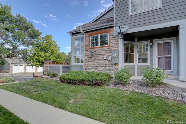 12812 Jasmine St Unit D, Thornton, CO 80602 - view of property exterior with stone siding and a lawn