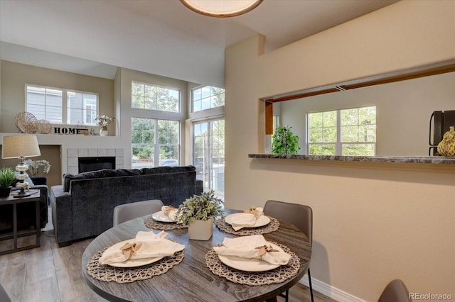 12812 Jasmine St Unit D, Thornton, CO 80602 - dining area featuring healthy amount of natural light, wood finished floors, a fireplace, and a towering ceiling