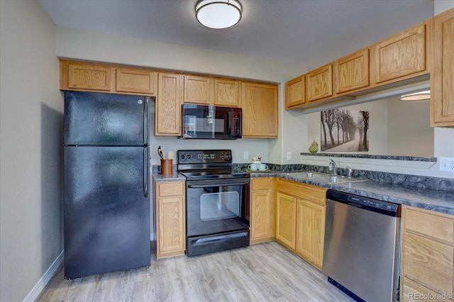 12812 Jasmine St Unit D, Thornton, CO 80602 - kitchen with black appliances, dark countertops, and light wood-style floors