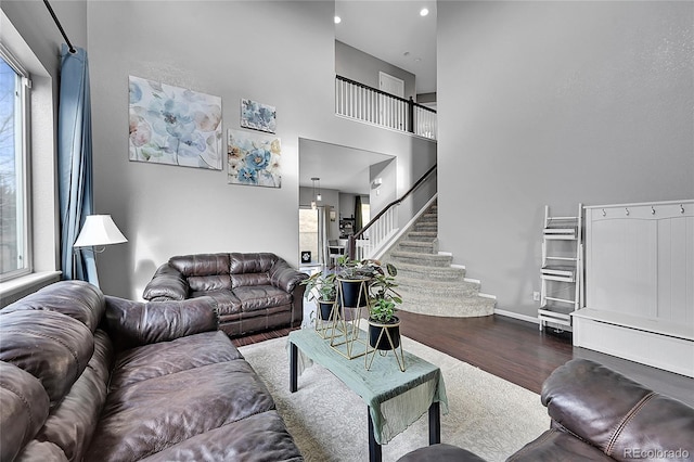 living room featuring dark hardwood / wood-style flooring and a towering ceiling