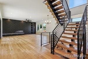 2620 N Perry St, Denver, CO 80212 - staircase featuring wood finished floors and a chandelier