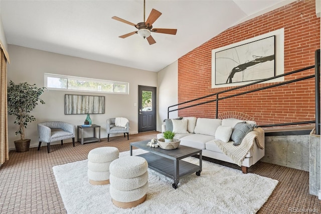 carpeted living room featuring lofted ceiling, brick wall, and ceiling fan