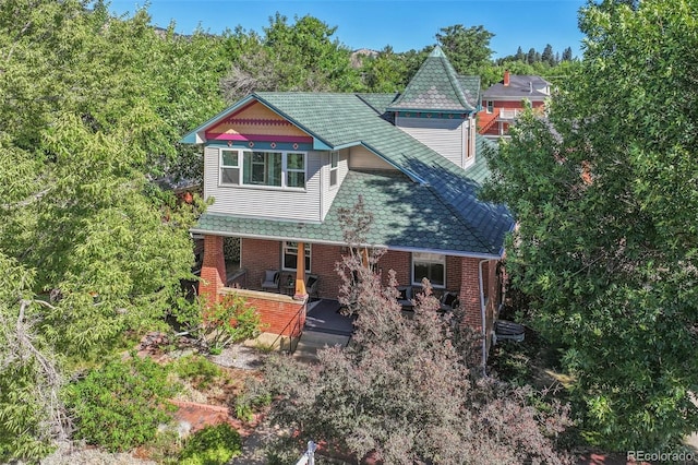 exterior space featuring covered porch and brick siding